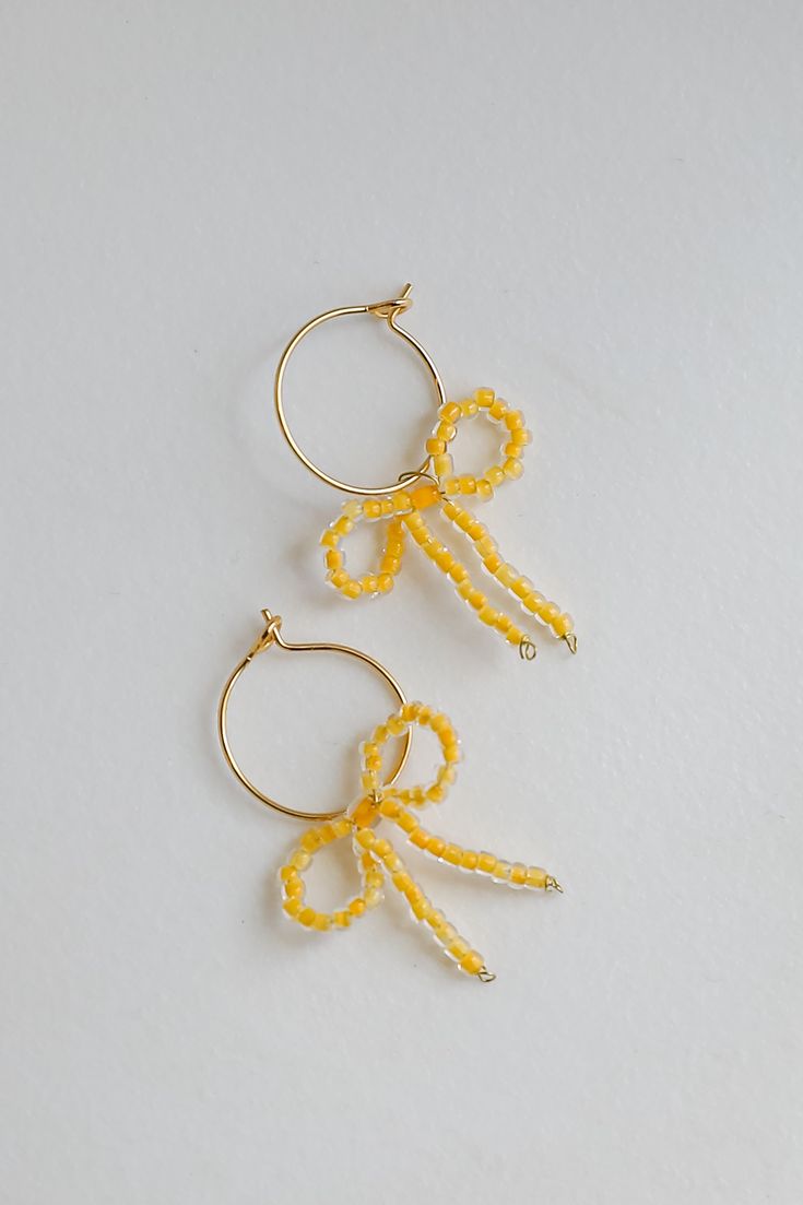 Feel and look like your best self every time you add the Sara Gold Bow Drop Earrings to your daily ensemble! These trendy earrings start with a kidney wire hoop back with beaded bows on the end. Add these fun earrings to a black dress + heels to add a chic touch to your date night look! Gold Plated Beaded Bows Hoop Kidney Wire Back One Size | Length 1.25” Adjustable Wrap Earrings For Party, Adjustable Wrap Earrings For Summer Gifts, Trendy Wrap Earrings With Ear Wire For Party, Adjustable Dangle Wrap Earrings For Party, Yellow Dangle Hoop Earrings For Party, Small Hoop Beaded Earrings For Party, Trendy Adjustable Wrap Earrings For Party, Party Small Hoop Beaded Earrings, Adjustable Hoop Beaded Earrings For Party