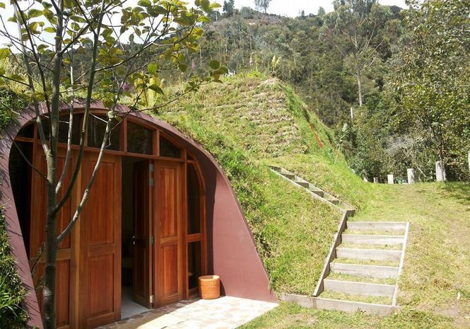 the entrance to a hobbot with steps leading up to it and a green roof