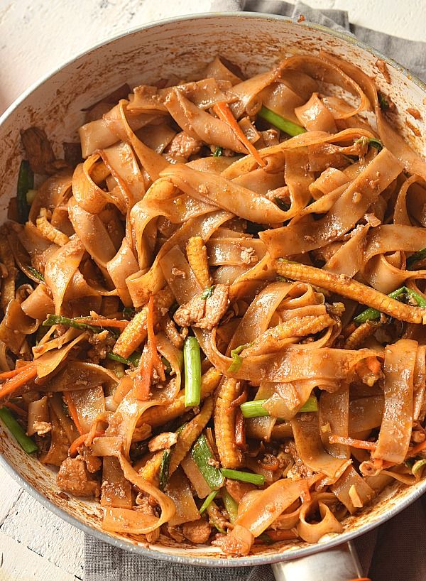 a pan filled with noodles and vegetables on top of a table