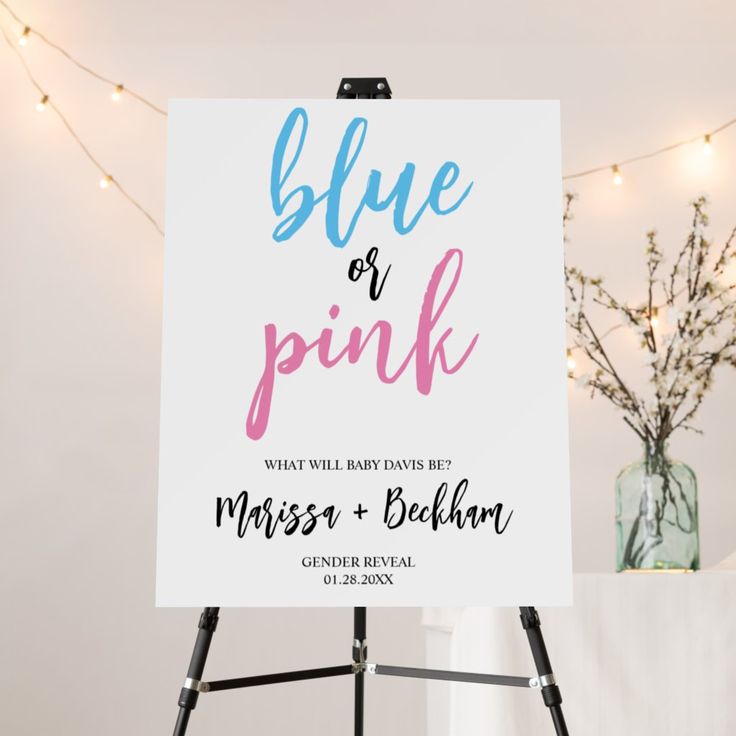 a blue and pink sign sitting on top of a easel next to a vase