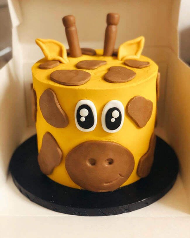 a cake shaped like a giraffe in a box