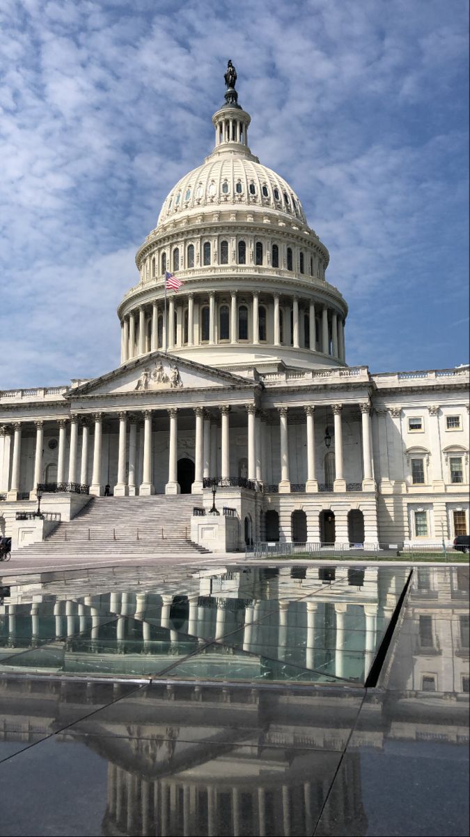 the u s capitol building in washington, d c is reflected in a pool of water