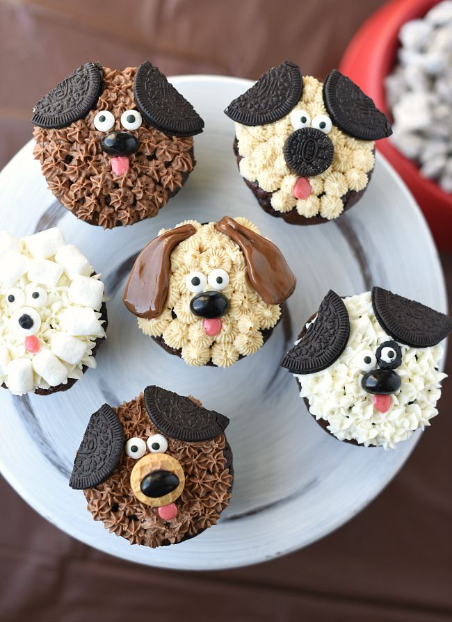 cupcakes decorated like dogs and sheep on a plate