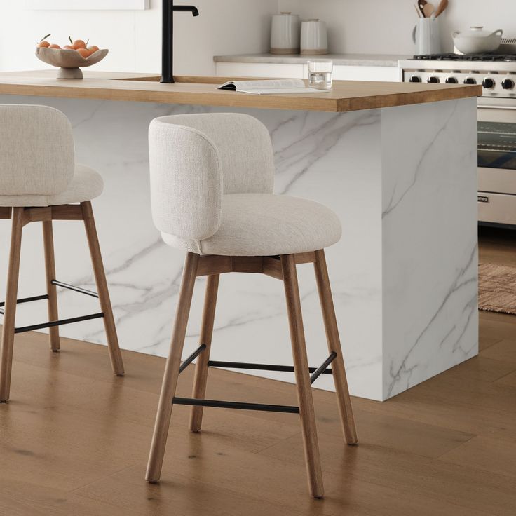 two white stools sitting in front of a counter