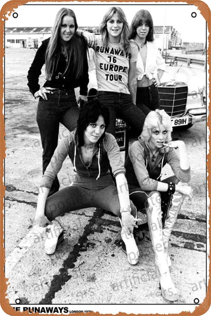 the runaways posing for a photo in front of an old car with their name on it