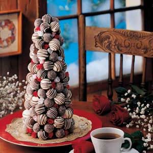 a christmas tree made out of cookies sitting on a table next to a cup of coffee