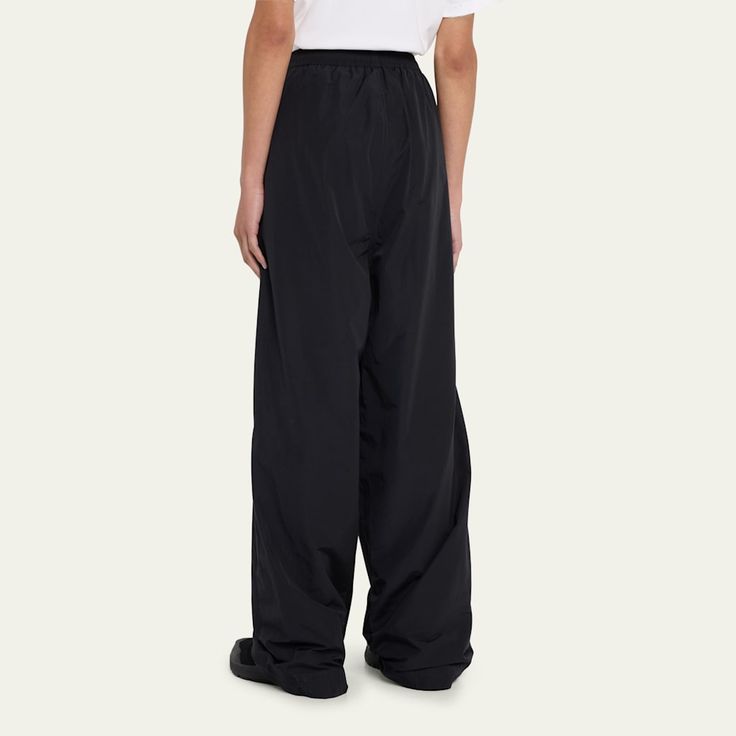 Balenciaga wide-leg tracksuit pants High rise; elastic waist  Side slip pockets Logo embroidery at the hip  Full length Relaxed fit  Cotton/nylon/polyamide Made in Italy Wide Leg Nylon Pants With Elastic Waistband, Wide-leg Nylon Pants With Elastic Waistband, Nylon Wide-leg Pants With Elastic Waistband, Wide Leg Nylon Pants With Loosely Fitted Hips, Loosely Fitted Wide Leg Nylon Pants, Tracksuit Pants, Logo Embroidery, Embroidery Logo, Balenciaga