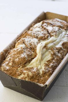 a loaf of cinnamon bread sitting in a pan on top of a white countertop