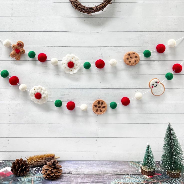 the christmas garland is decorated with cookies and pom - poms, along with other holiday decorations