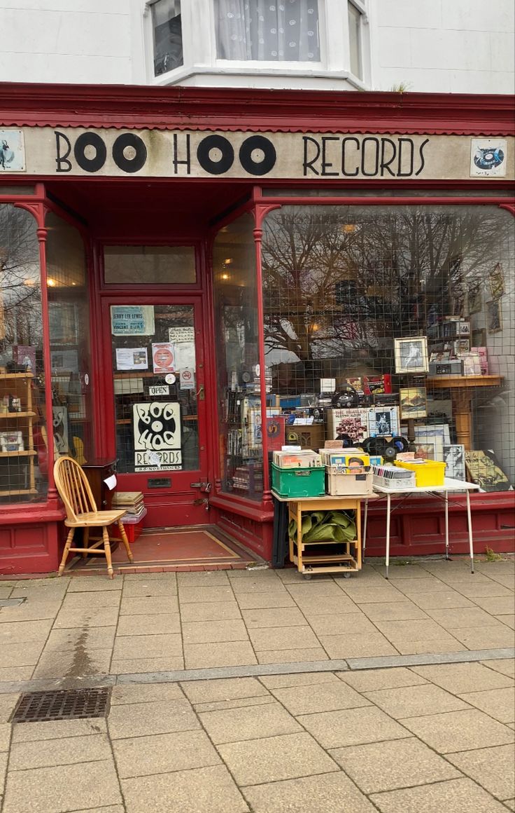 the outside of a record shop with chairs and tables