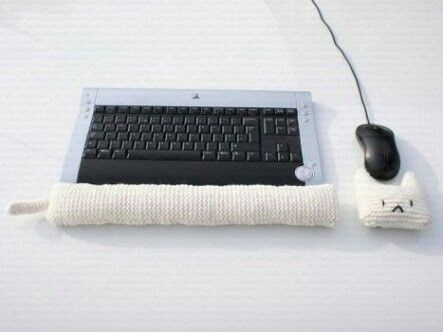 a computer keyboard and mouse sitting next to each other on a white surface with a piece of cloth wrapped around it