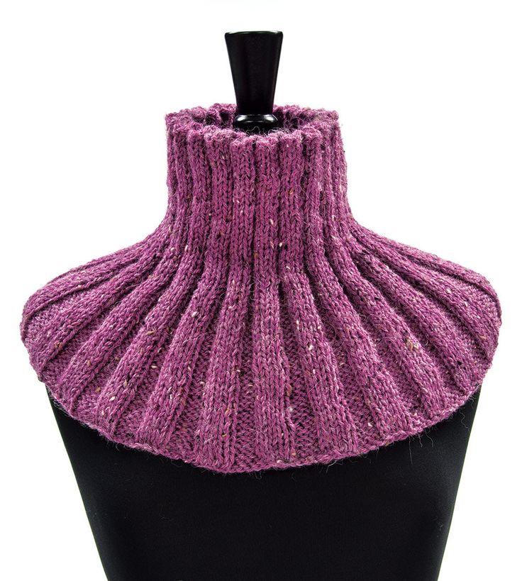 a mannequin wearing a purple knitted neckwarf on a black stand