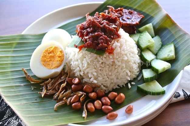 a plate with rice, beans, and an egg on top of it next to sliced cucumbers