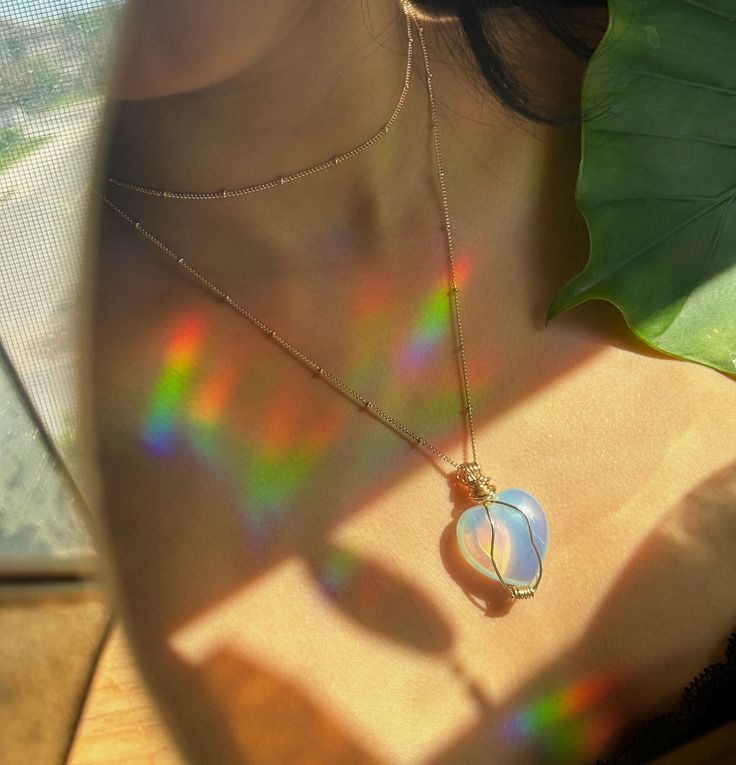 Opalite is a man-made stone that is created from glass and other substances. Opalite emanates new beginnings and stimulates positive energy. This stone helps calm the mind and brings back balance into the wearer's life. Opalite strengthens relationship with optimism, love, and hope.  This heart shaped pendant is made from non-tarnish wire paired with nickel free necklace chain. Iridescent Crystal Necklaces For Healing, Spiritual Chalcedony Jewelry For Meditation, Iridescent Necklaces With Natural Stones For Healing, Iridescent Moonstone Necklace For Healing, Spiritual Hypoallergenic Necklace For Healing, Necklace Photography, Opalite Crystal, Heart Shaped Pendant, Crystal Heart Pendant