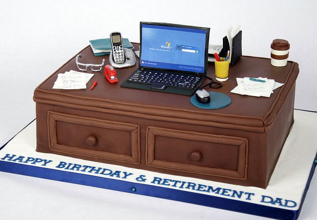 a cake shaped like a desk with a laptop and cell phone on it that says happy birthday & retirement dad