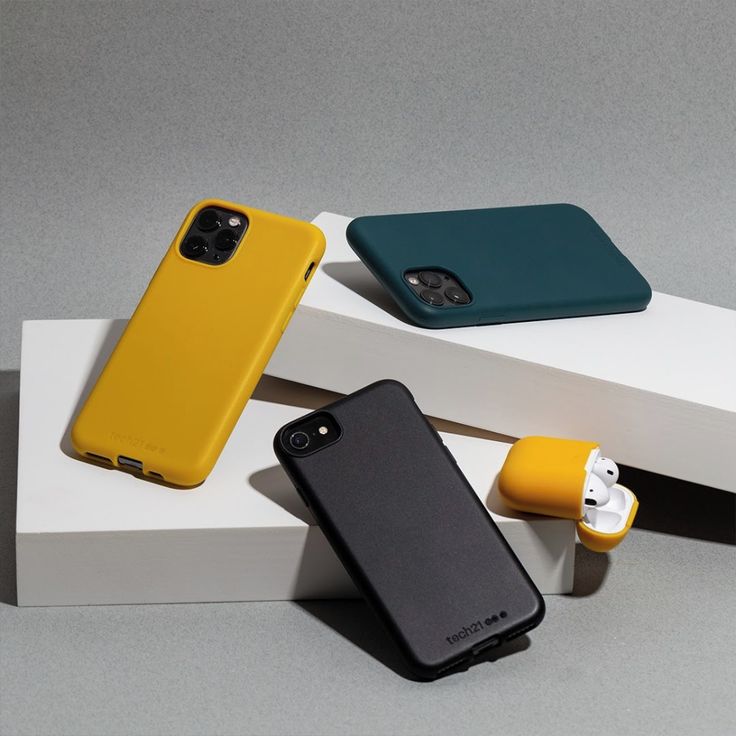 three cell phones sitting on top of each other in different colors and sizes, next to one another