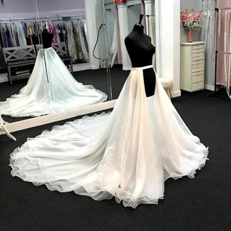 a wedding dress is displayed in front of a mannequin and dresses are on display