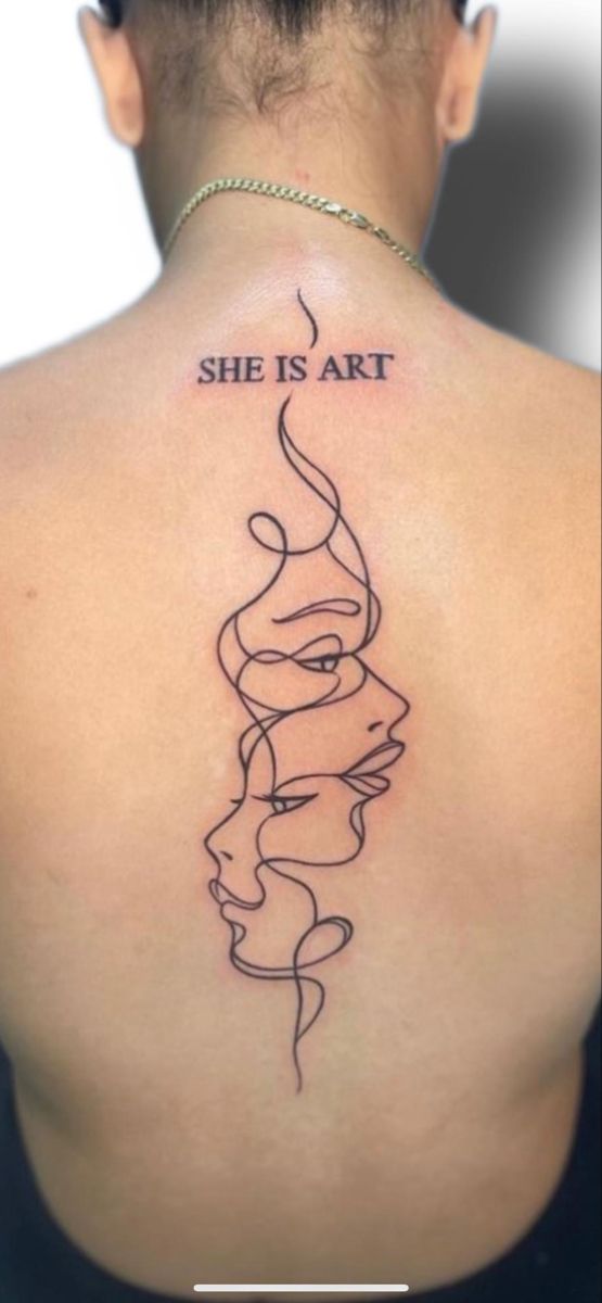 the back of a woman's neck with a tattoo saying she is art on it