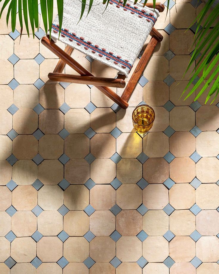 an overhead view of a tiled floor with a chair and potted plant on it