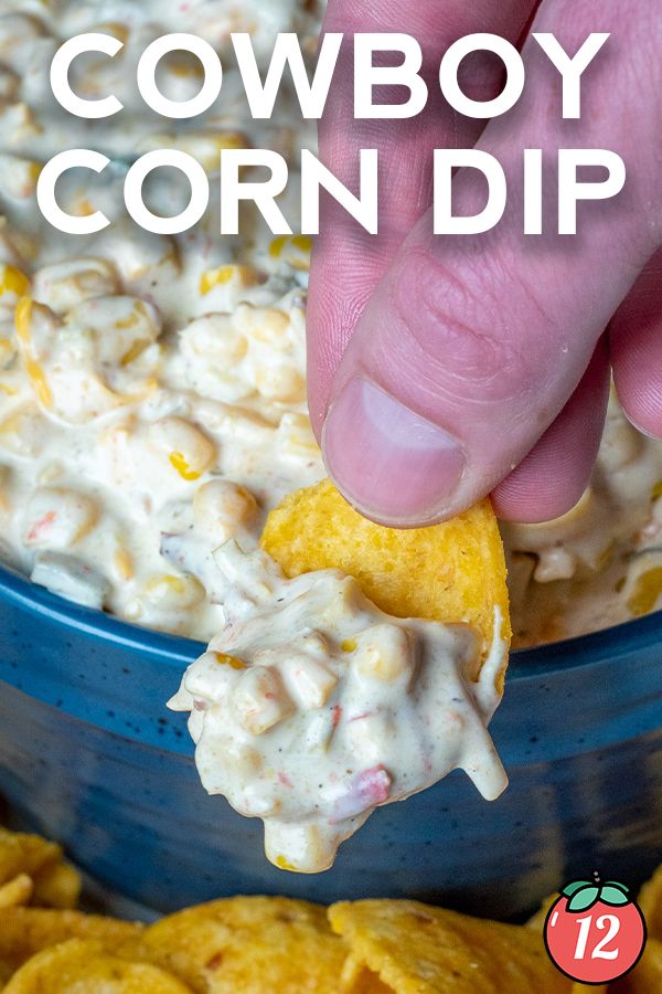 a hand dipping a tortilla chip into a bowl of cowboy corn dip with the text overlay