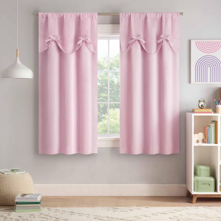 the pink curtains in this room are ready to be hung on the window sill