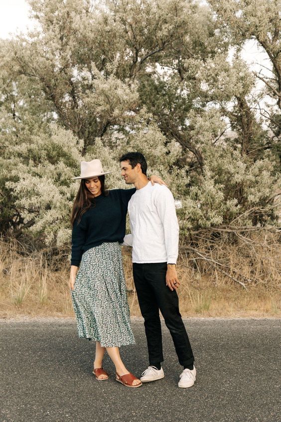 a man and woman standing next to each other on the road