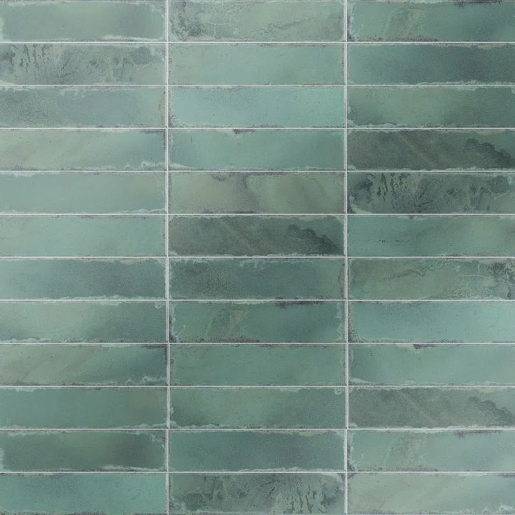 a green tile wall that looks like it has been painted in different shades and sizes