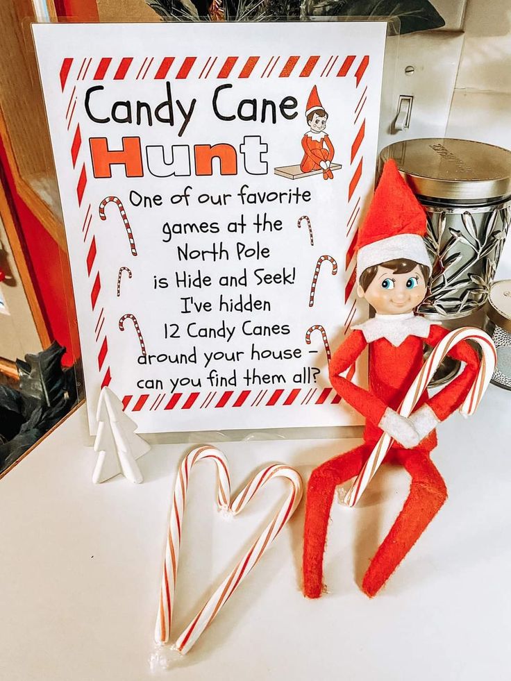 an elf is sitting next to a candy cane sign