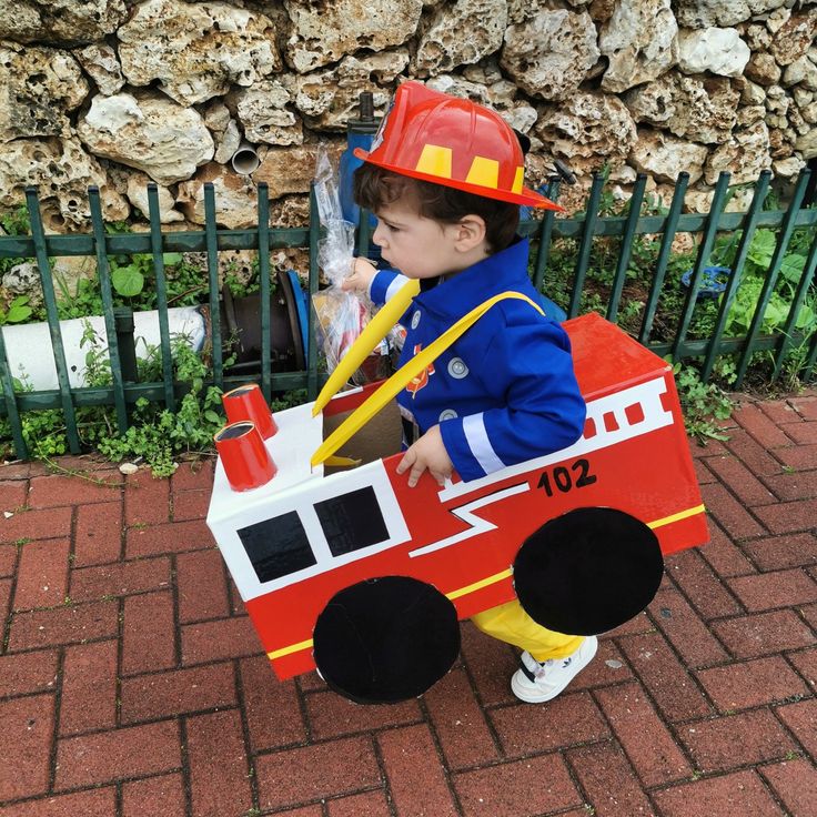 a small child in a fire truck costume