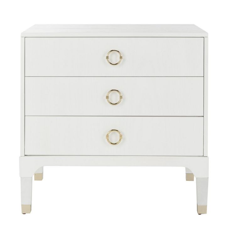 a white dresser with three drawers and two gold rings on the bottom drawer, against a white background