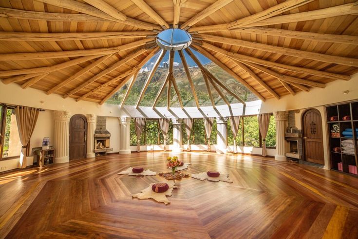 a large room with wooden floors and a skylight in the center that is made from wood planks