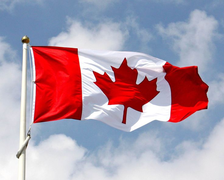 the canadian flag is flying high in the sky