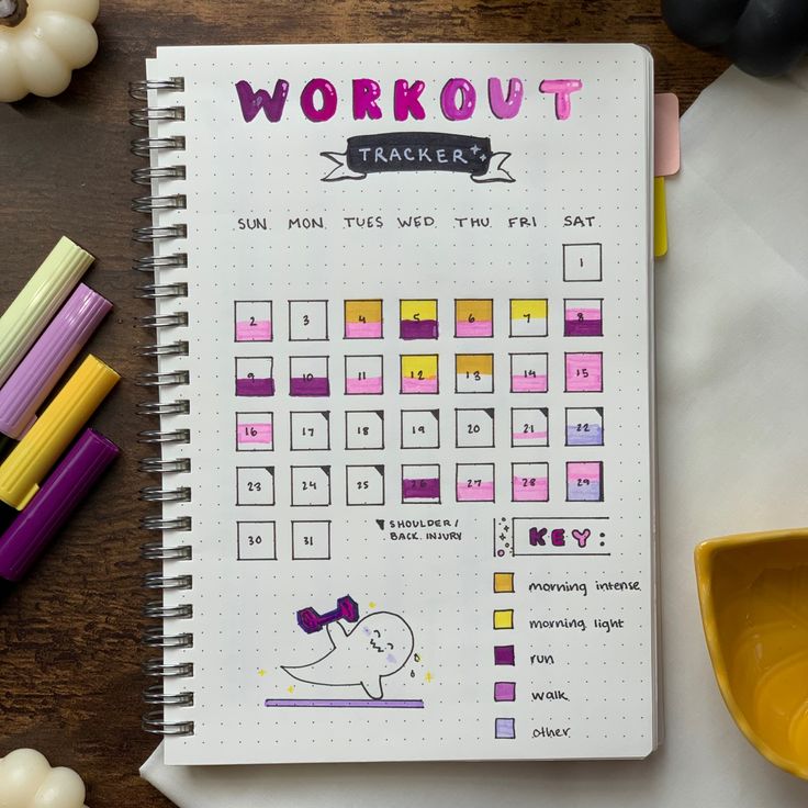 a notebook with the words workout tracker written on it next to some crayons