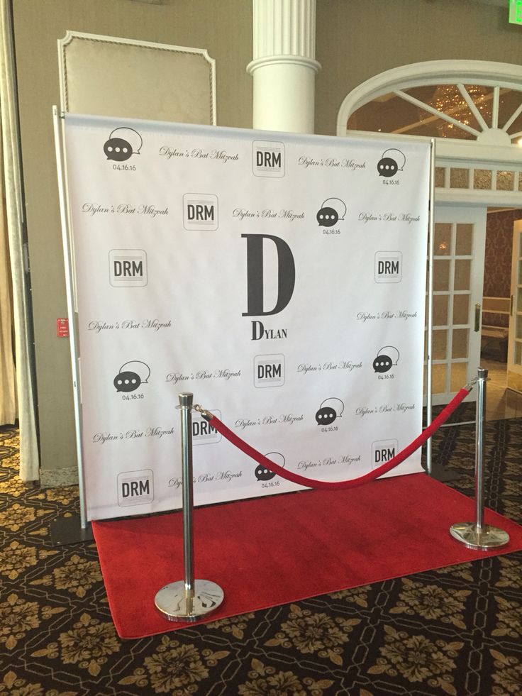 a red carpeted area in front of a white sign with the letter d on it