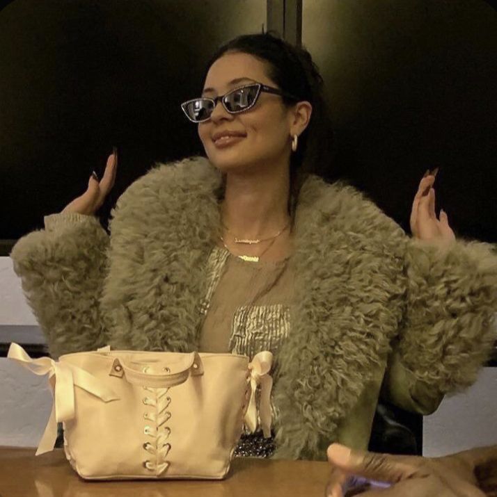 a woman sitting at a table with a purse