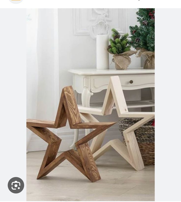 two wooden stars sitting on the floor next to a basket with red flowers in it