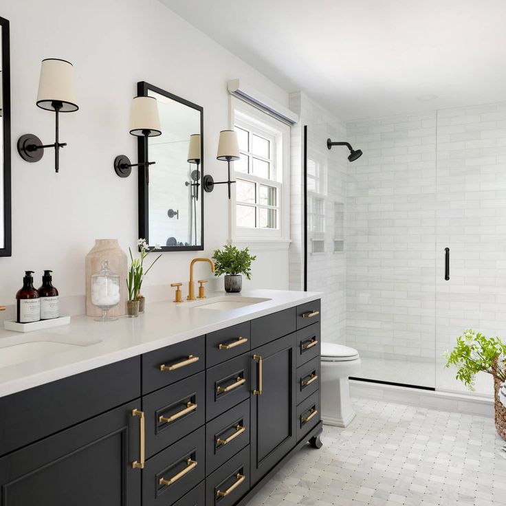 a white and black bathroom with gold handles