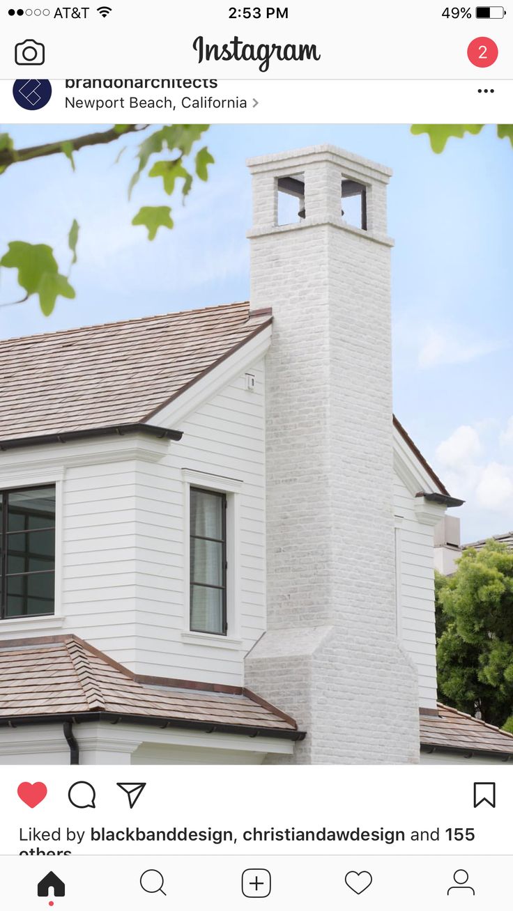 an instagram photo of a white house with a clock tower in the center and trees behind it