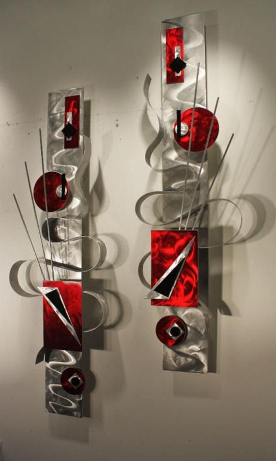 two red and white abstract artwork pieces hanging on a wall