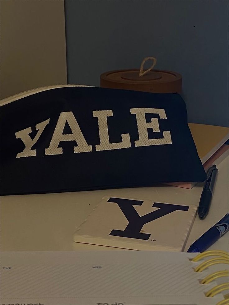 a black and white bag sitting on top of a desk next to a notepad