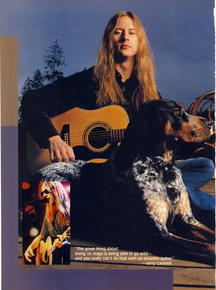 a woman sitting next to a dog with an acoustic guitar