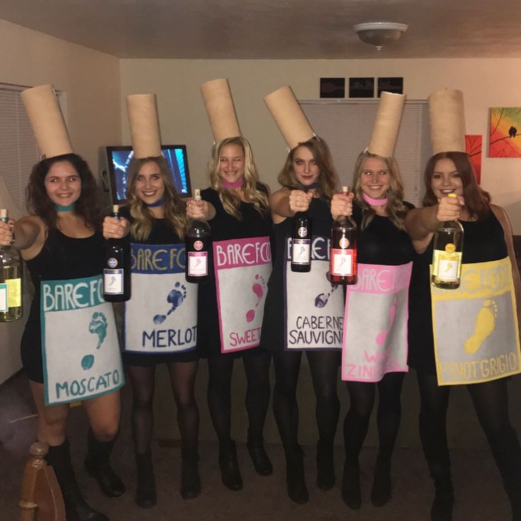 the women are holding up their wine bottles with corks on them while posing for a photo