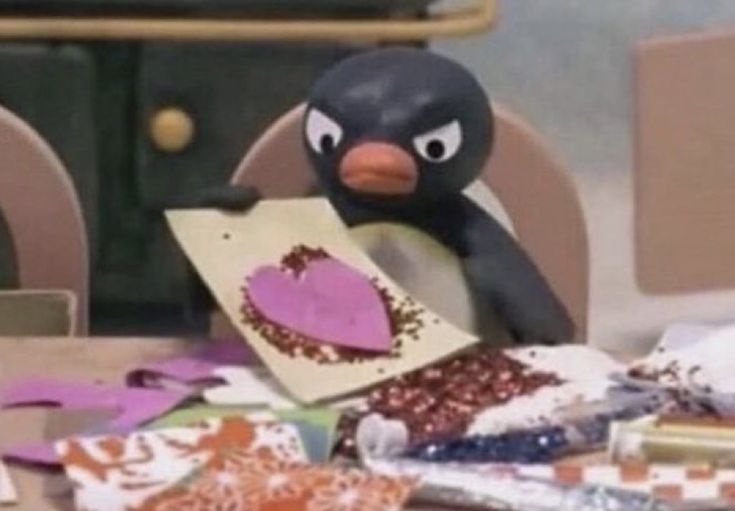 a penguin sitting at a table with some candy