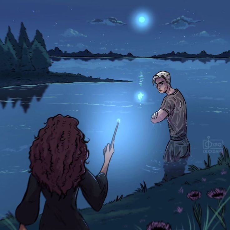 two people are standing in the water at night and one is holding a cell phone