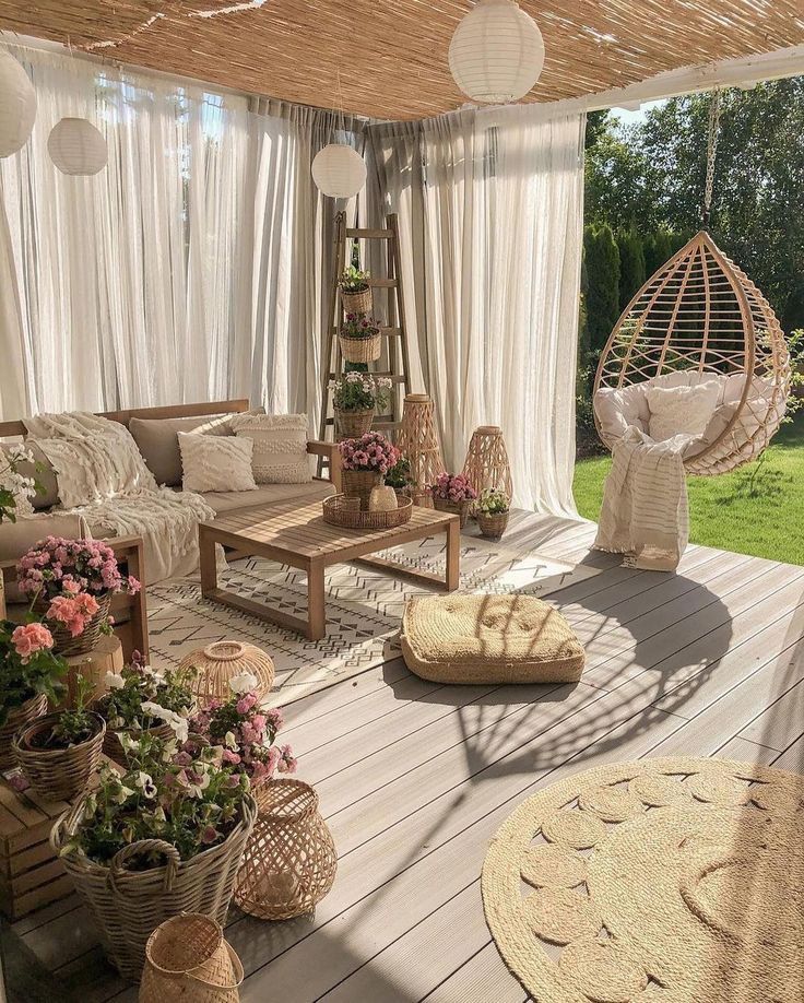 an outdoor living area with wicker furniture and hanging baskets on the floor, along with flowers