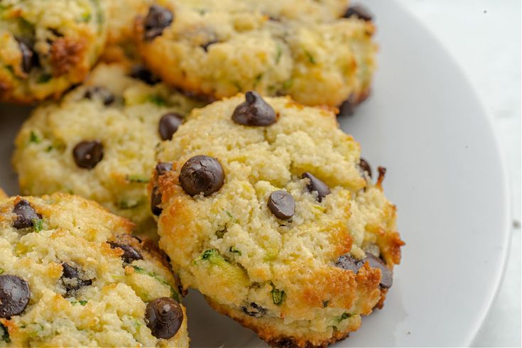 a white plate topped with muffins covered in chocolate chips