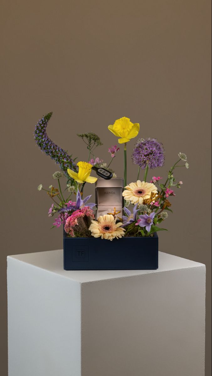 an arrangement of flowers in a blue box