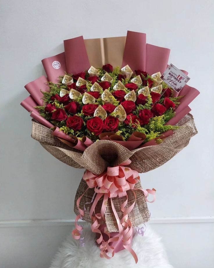 a bouquet of roses and chocolates wrapped in burlock