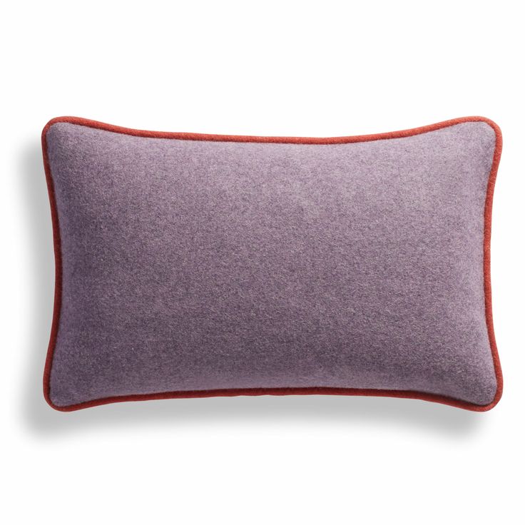 a purple and red pillow with an orange border on the bottom, in front of a white background