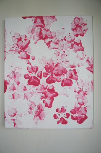 a painting is hanging on the wall with red and white paint splattered all over it